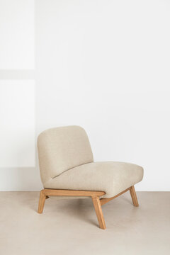 Minimal wooden chair with soft beige upholstery