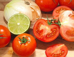 Assortment of fresh produce tomatoes, onion, and lime