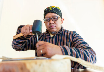 Javanese artisan working on handmade shadow puppets