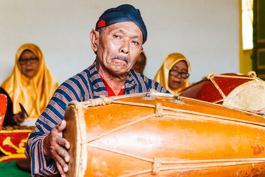 Traditional Javanese musician playing a gamelan drum