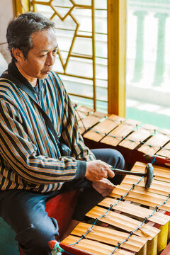 Traditional Javanese musician playing gamelan instrument