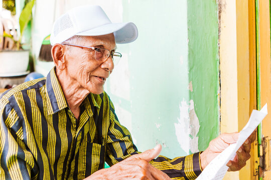 Elderly man with musical score in traditional setting