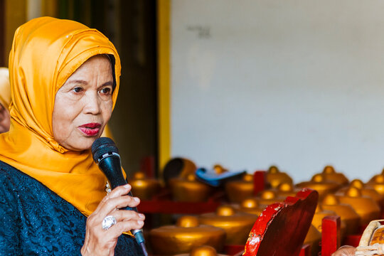 Woman with microphone performing traditional Javanese music