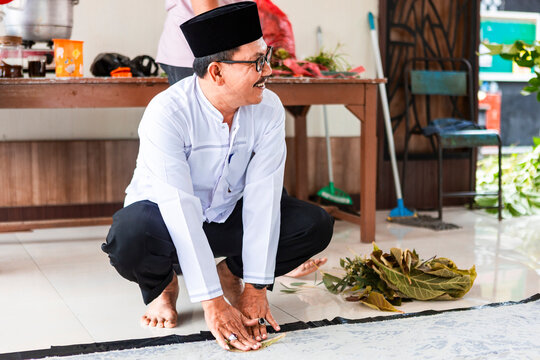 Indonesian Artisan Working with Leaves in Traditional Batik Process