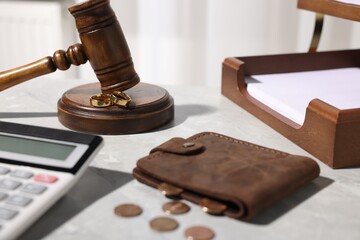 Alimony. Wallet, coins, calculator, wedding rings, gavel and documents on grey marble table, closeup