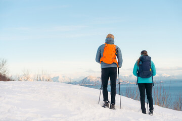 Couple exploring snowy Lofoten landscape in winter