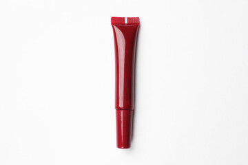 Beautiful dark red lip gloss on white background, top view