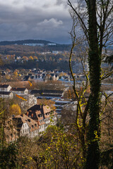 Blick vom Berg nach unten durch Bäume in die Stadt Marburg nach Ockershausen, herbstliches Sonnenwetter im November