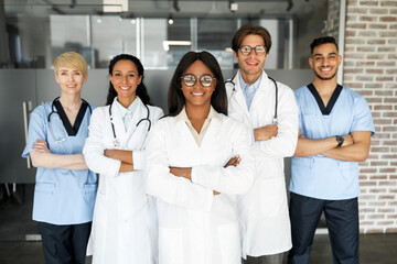 Multiracial professional team of newest modern clinic or hospital posing together while having...