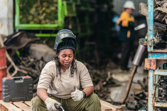 Female Welder Cutting Metal with Torch in Industrial Workshop