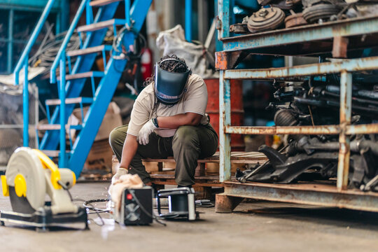 Female Welder Cutting Metal with Torch in Industrial Workshop