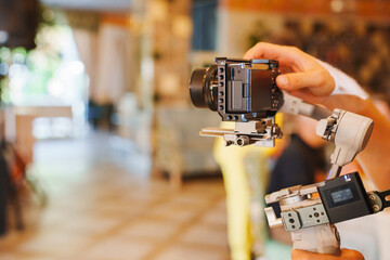 Person holding camera and gimbal stabilizer indoors