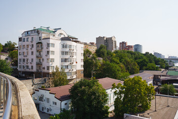 Cityscape view of buildings beside green trees in summer