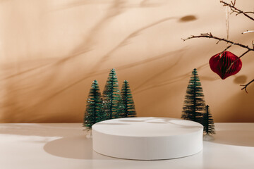 Winter holiday podium with christmas trees at the background and beautiful shadows. Background for...