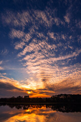 Obraz premium Mackerel Sky, clouding sunset reflected in the still water of a lake. Swithland Reservoir, Swithland, Leicestershire.