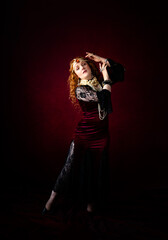  A beautiful pensive bohemian woman with long red hair, dressed in a red velvet dress with black lace, wearing pearl necklaces and an amber jewel headdress