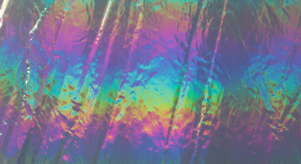 Iridescent holographic foil background with vibrant rainbow colors and crumpled texture