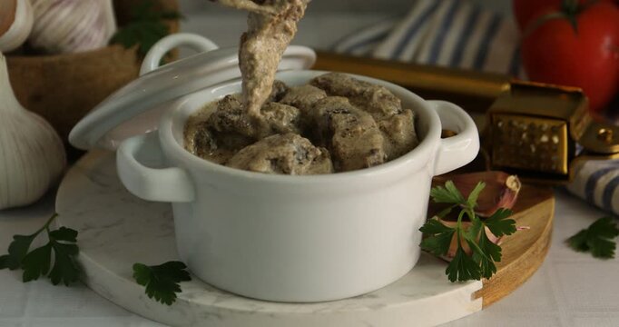 Eating tasty beef stroganoff at white tiled table, closeup