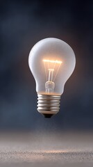 Illuminated Lightbulb with Water Droplets and Visible Filament Glowing Against a Dark, Atmospheric Backdrop