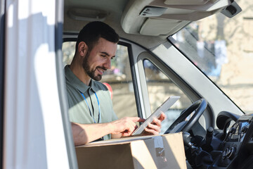 close up shot of Delivery man using digital tablet inside van © Cristina Garcia