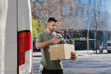 Delivery man scanning package with phone for logistics tracking
