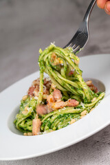 Recipe for linguine pasta with spinach pesto, smoked bacon, and Parmesan cheese. High quality photo