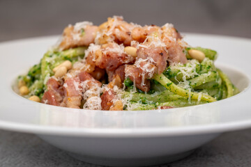 Recipe for linguine pasta with spinach pesto, smoked bacon, and Parmesan cheese. High quality photo