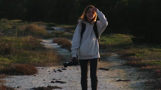 A woman walking slowly with camera at Gediz Delta in Sasalı Bird Paradise, clearly intending to photograph birds