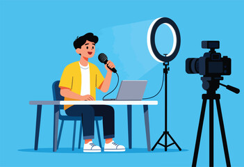 A person with a microphone sits at a table with a laptop, ring light and video camera in front of a blue background