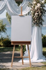 Blank canvas on easel at outdoor wedding near lake; draped backdrop