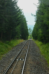 Fototapeta premium Track of the funicular cable railway – two rails supporting and guiding the wheels of rail vehicles, at a specified distance from each other, serving as a railway track