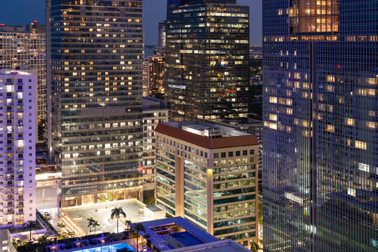 A nighttime view of the brightly lit office and apartment buildings in the dense Brickell neighborhood of Miami, Florida.
