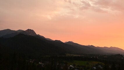 Beautiful, scenic sunset over Tatra mountains and Zakopane, Poland. Orange sky over the mountains