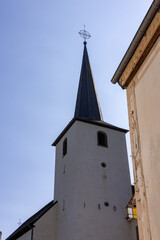 Fototapeta premium Esch-sur-Sure, Wiltz, Grand-Duche de Luxembourg, September 07, 2025, Timeless bell tower amid peaceful cityscape, Historical clock tower located within calm and charming city neighborhood
