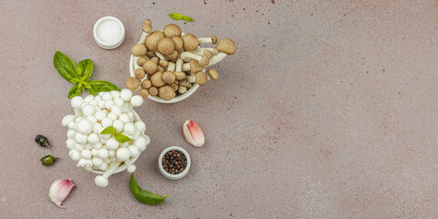 Fresh assorted shimeji mushrooms with olive oil, basil, garlic, salt, pepper on rustic background