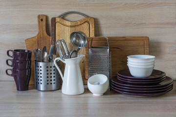 Kitchen still life as background for design. Crockery, tableware and other different stuff on wooden table-top.
