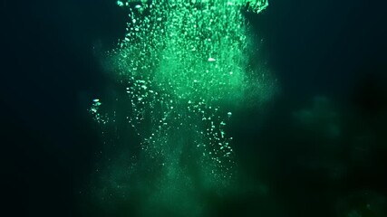 Underwater exploration uncovers an enchanting oceanic world where bubbles rise from the seafloor to meet the darkness above, featuring a green lit statue surrounded by undulating waves and a.