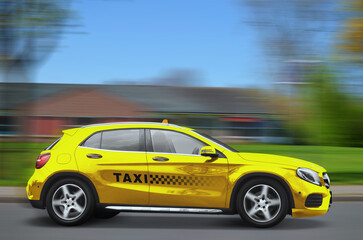 Yellow taxi car with top sign and logo driving on road. Motion blur effect