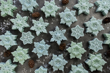 Snowflake shape candles. Mistletoe branches close up on gray background. decor for Christmas, Advent, Yule, New Year holidays.