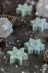 Snowflake shape candles. Mistletoe branches close up on gray background. decor for Christmas, Advent, Yule, New Year holidays.