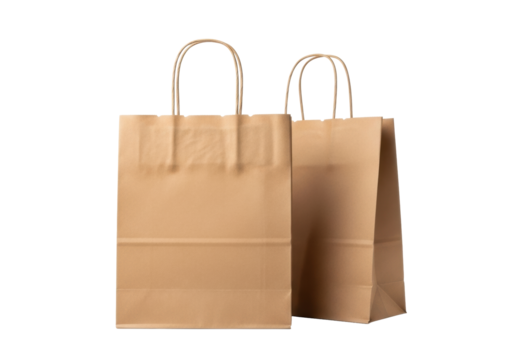 Two natural brown kraft paper shopping bags with twisted handles, one central, one angled, showcasing distinct texture on a transparent studio background, concept of eco-friendly packaging