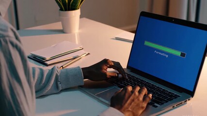 A Person Formatting a Laptop At Home. DIY Home Tech Fix and System Reset.