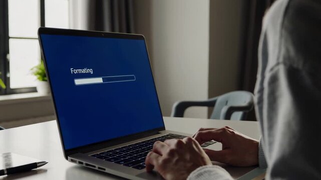 A Person Formatting a Laptop At Home. DIY Home Tech Fix and System Reset.