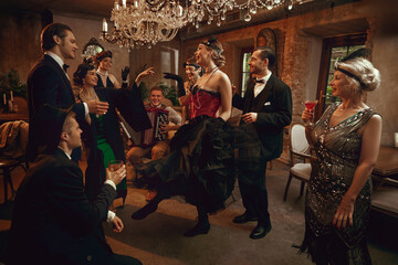 Retro friends gathered around dancer performing in vintage bar under crystal chandelier. Concept of themed retro evenings, nightlife branding, luxury event marketing, creative entertainment visuals.