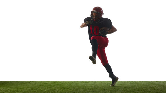 American football player jumping forward with intense determined emotion on field isolated on white background. Concept of sport action, athlete training, performance analysis, promo use. - Powered by Adobe