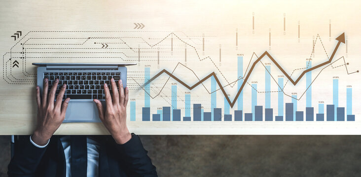 A business professional engages in data analysis on a laptop, surrounded by digital graphics depicting growth trends, emphasizing modern office productivity and financial strategy. Scalp