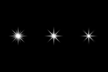 Fototapeta premium Three white star light flare effects on a black background