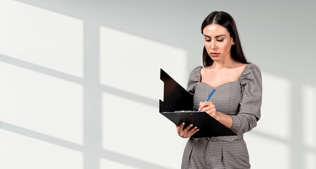 Businesswoman taking notes on clipboard, realistic style, standing in front of white background with window shadows, concept of productivity