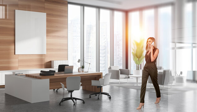 Confident businesswoman walking and talking on phone in modern office with wood panels, large windows, cityscape view, and stylish furniture concept