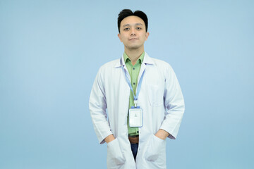 Friendly Asian medical or science professional in a lab coat and ID badge, standing relaxed in blue...